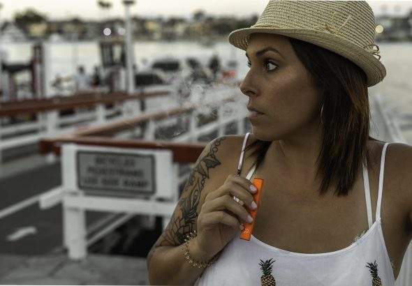 2026 年高階玩家在戶外環境下使用搭載氮化鎵（GaN）電源技術的微型霧化設備，展示設備的小巧體積與高效能